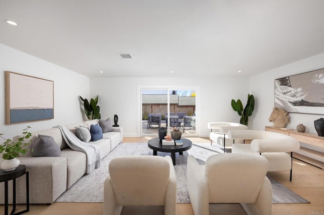 living room with recessed lighting, visible vents, and light wood-style flooring