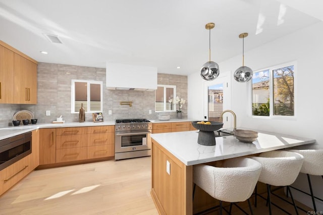 kitchen with decorative backsplash, a breakfast bar area, appliances with stainless steel finishes, and modern cabinets