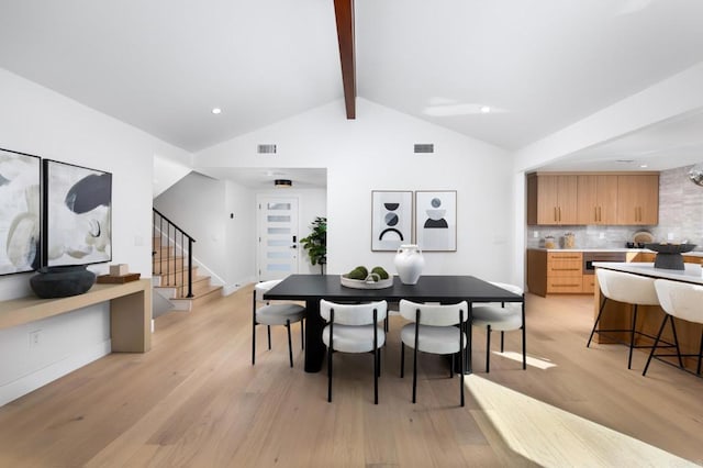 dining space featuring visible vents, vaulted ceiling with beams, baseboards, stairs, and light wood-style flooring