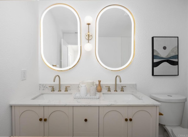 bathroom featuring a sink, toilet, and double vanity