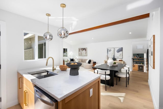 kitchen featuring light wood finished floors, dishwasher, lofted ceiling, light stone counters, and a sink