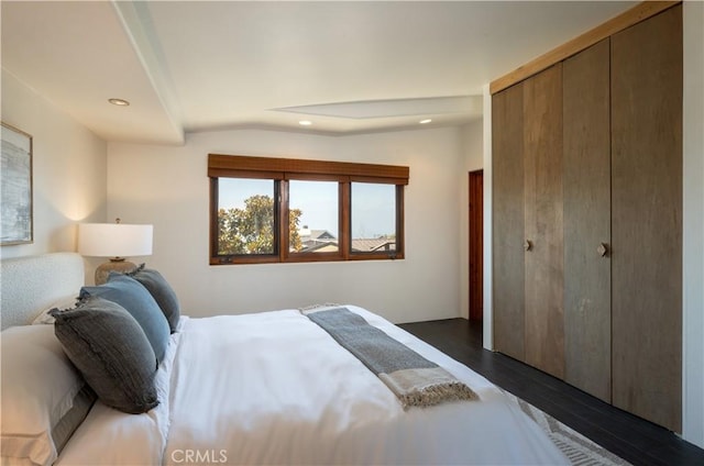 bedroom with lofted ceiling, recessed lighting, a closet, and dark wood-style flooring