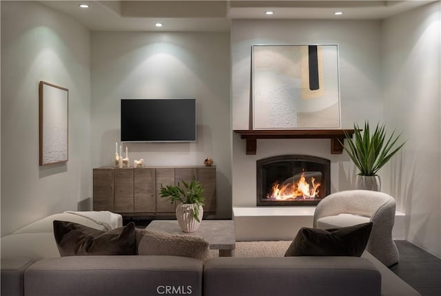 living area with recessed lighting and a glass covered fireplace