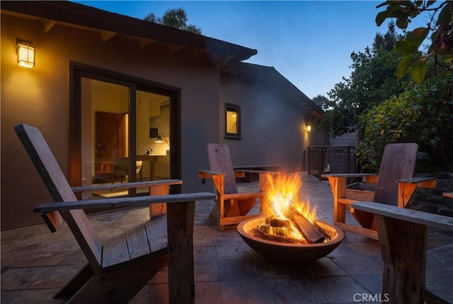 patio terrace at dusk featuring an outdoor fire pit