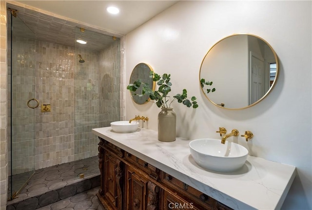 full bathroom featuring a tile shower, recessed lighting, double vanity, and a sink