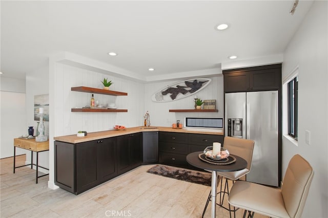 kitchen featuring open shelves, recessed lighting, stainless steel fridge with ice dispenser, and light wood-style floors