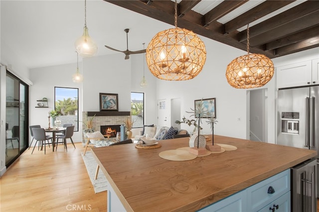 kitchen featuring a wealth of natural light, wine cooler, light wood-style floors, a fireplace, and high end refrigerator