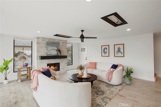 living room with light wood finished floors, recessed lighting, a fireplace, and baseboards