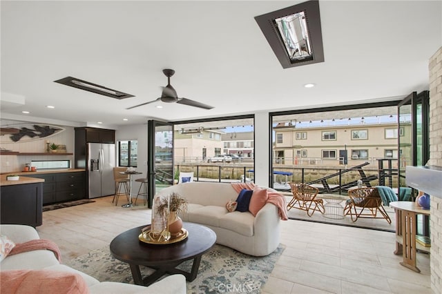 living area featuring recessed lighting, a skylight, and a ceiling fan