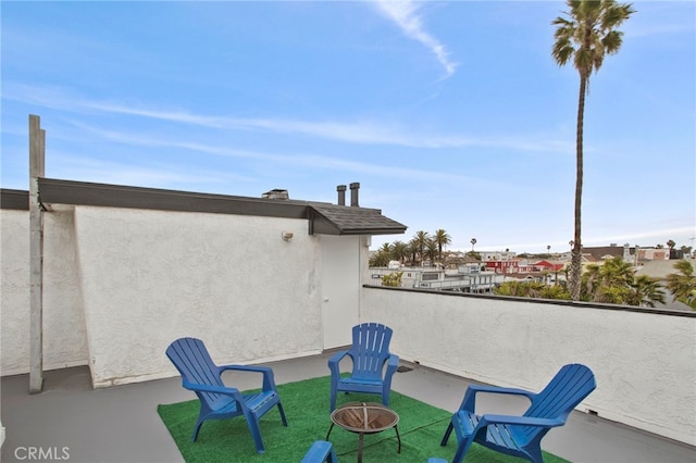 view of patio featuring a balcony and an outdoor fire pit