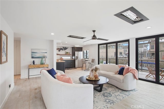 living area with a ceiling fan, light wood-style flooring, recessed lighting, and baseboards