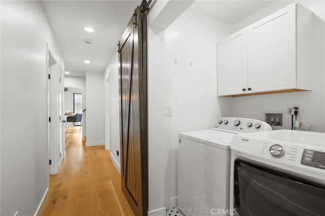 laundry area with light wood finished floors, recessed lighting, cabinet space, a barn door, and washing machine and dryer