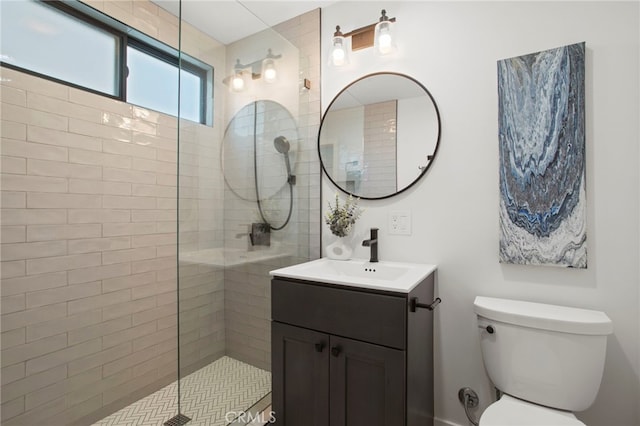 full bathroom featuring vanity, toilet, and tiled shower