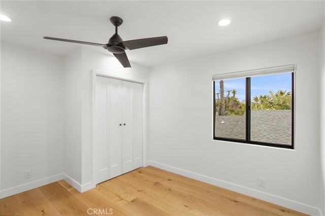 unfurnished bedroom with light wood-type flooring, baseboards, and a closet