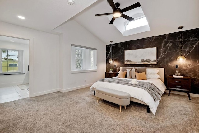 carpeted bedroom featuring vaulted ceiling with skylight, recessed lighting, multiple windows, and an accent wall