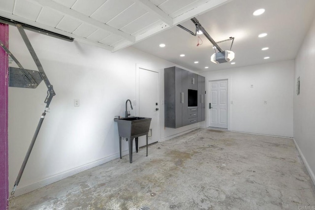 garage with recessed lighting, a garage door opener, and baseboards