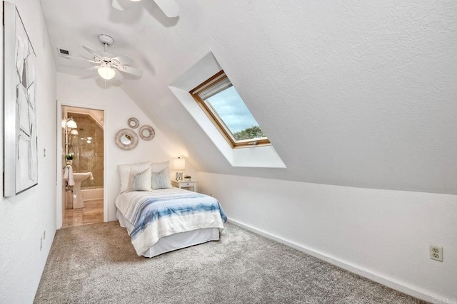 bedroom featuring lofted ceiling with skylight, carpet floors, and a textured ceiling