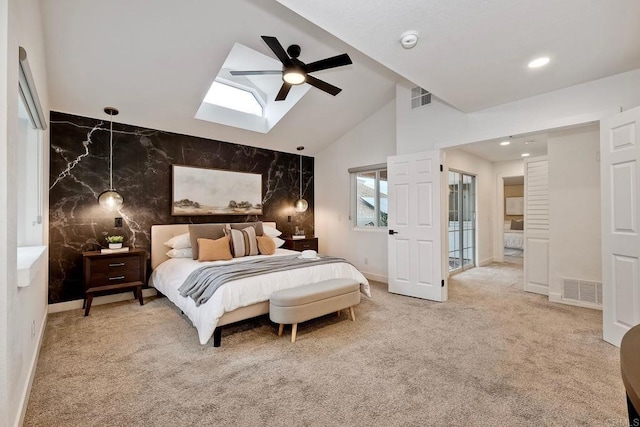 bedroom featuring visible vents, vaulted ceiling with skylight, carpet, and an accent wall