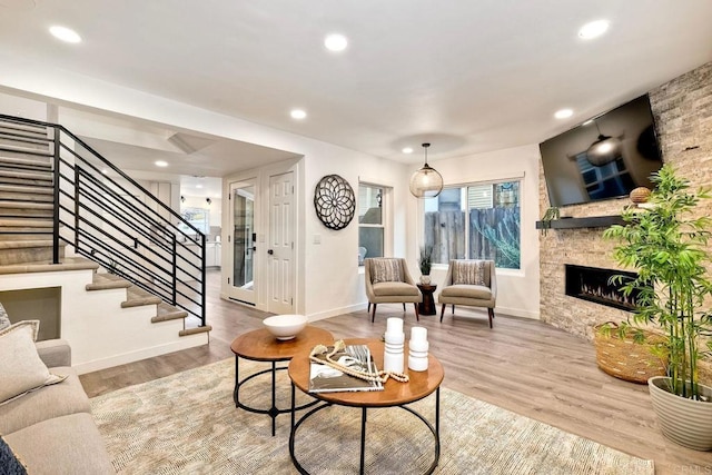 living room with stairway, wood finished floors, baseboards, recessed lighting, and a fireplace