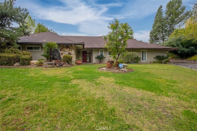 view of front facade featuring a front lawn, stone siding, and stucco siding