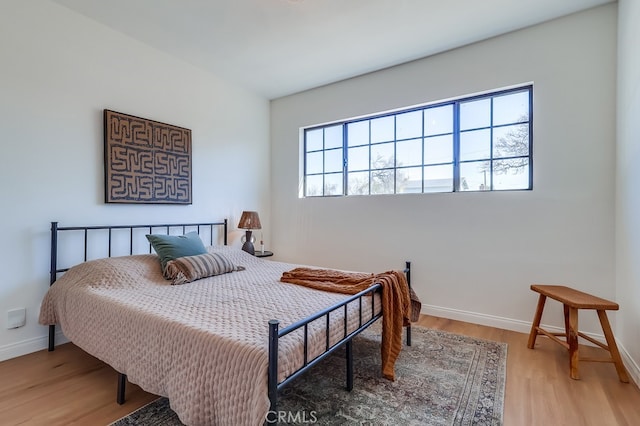 bedroom featuring baseboards and wood finished floors