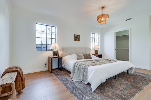 bedroom with visible vents, baseboards, and light wood-style flooring