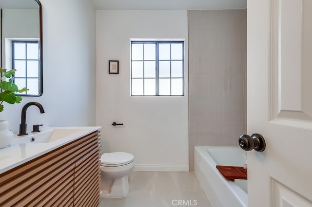 bathroom with baseboards, toilet, and vanity