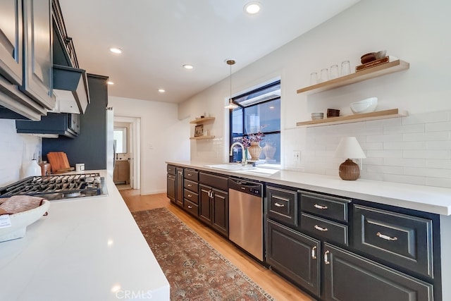 kitchen featuring open shelves, light wood-type flooring, recessed lighting, stainless steel appliances, and a sink