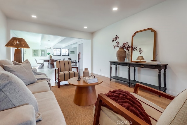 living area featuring a notable chandelier, recessed lighting, baseboards, and wood finished floors