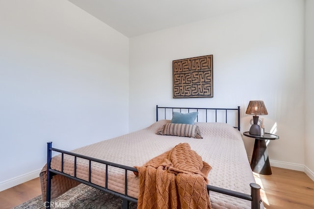 bedroom featuring wood finished floors and baseboards