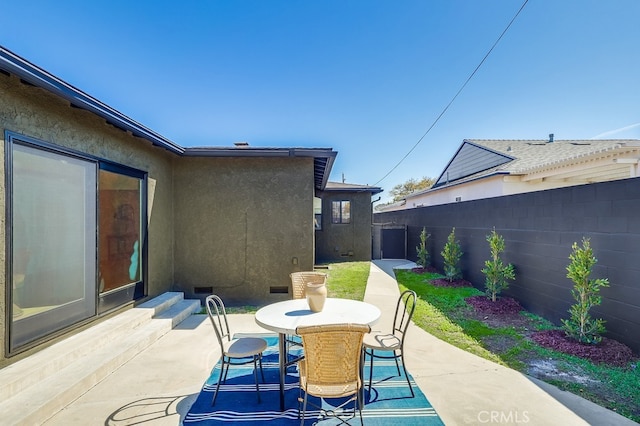 view of patio featuring outdoor dining space and fence