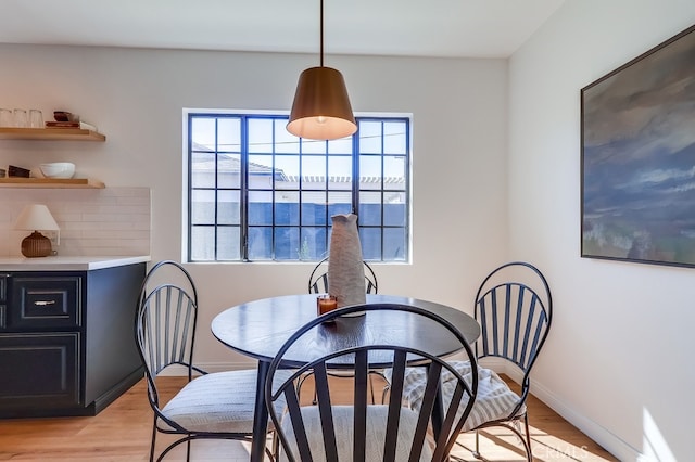 dining area with light wood-type flooring and baseboards