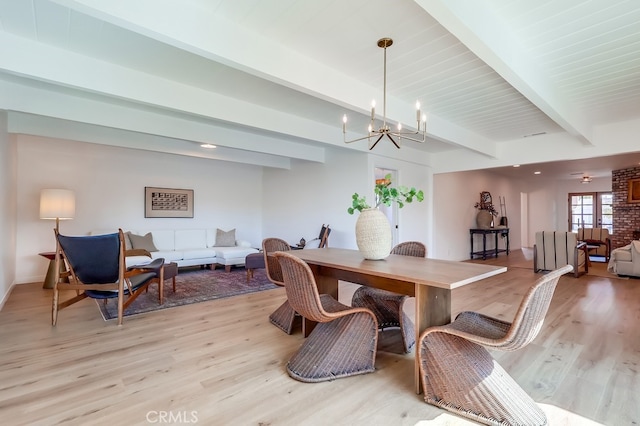 dining room featuring beam ceiling, light wood finished floors, and an inviting chandelier