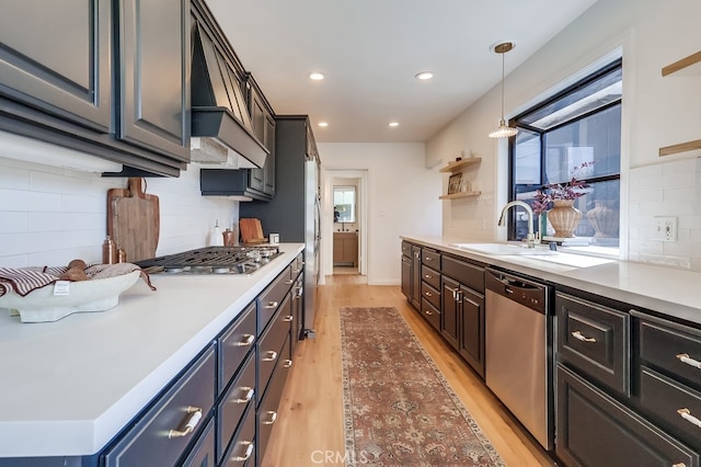 kitchen featuring a healthy amount of sunlight, light wood-type flooring, appliances with stainless steel finishes, and a sink