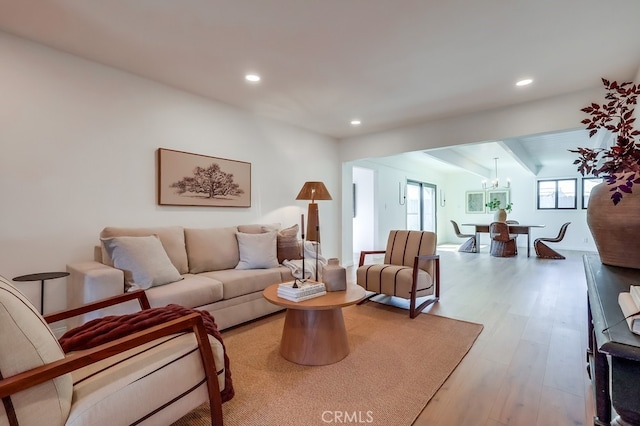 living room featuring a notable chandelier, recessed lighting, and wood finished floors