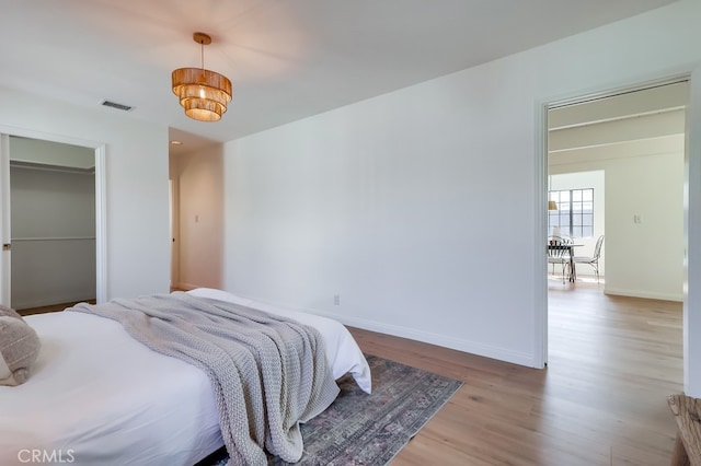 bedroom featuring visible vents, baseboards, and wood finished floors