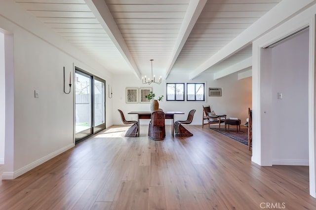 dining room with baseboards, light wood finished floors, a wall mounted air conditioner, beamed ceiling, and a notable chandelier