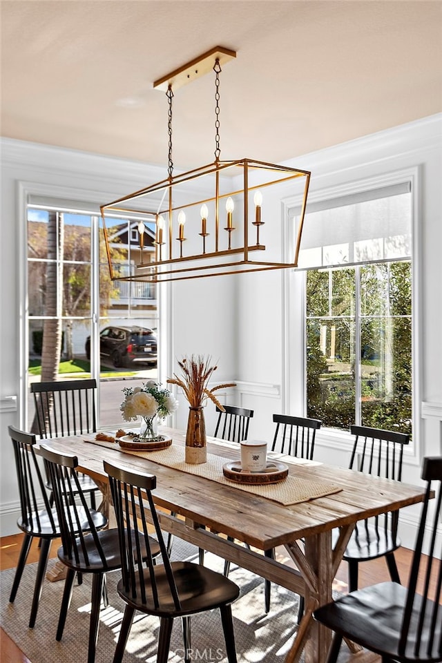 dining space featuring wood finished floors and ornamental molding