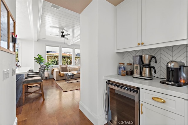 bar with baseboards, beverage cooler, decorative backsplash, wood finished floors, and a ceiling fan