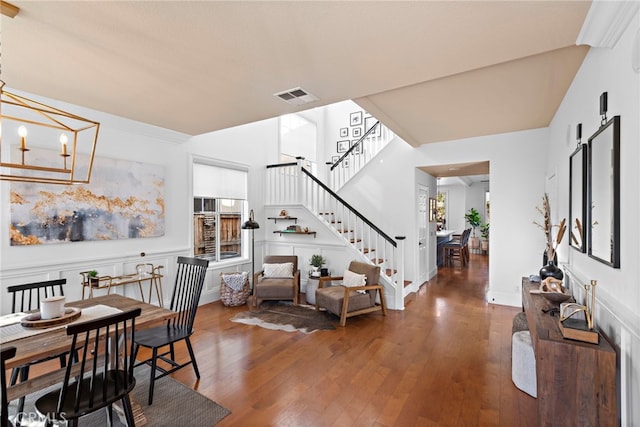 dining room featuring baseboards, visible vents, stairs, wood-type flooring, and a chandelier