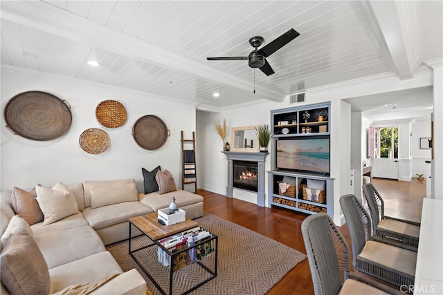 living room featuring visible vents, beam ceiling, wood finished floors, a glass covered fireplace, and recessed lighting