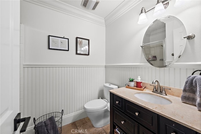 bathroom with visible vents, toilet, ornamental molding, wainscoting, and vanity