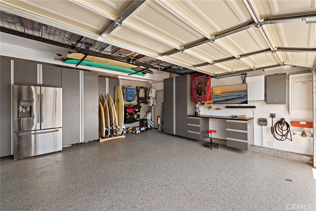 garage featuring stainless steel refrigerator with ice dispenser