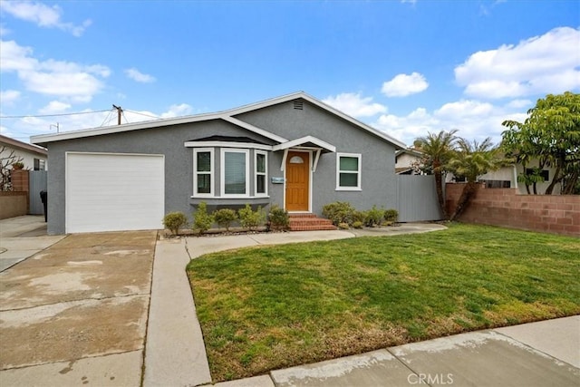 view of front facade with fence, a front yard, stucco siding, a garage, and driveway