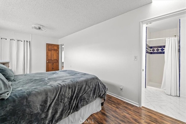 bedroom featuring dark wood-type flooring, baseboards, and a textured ceiling