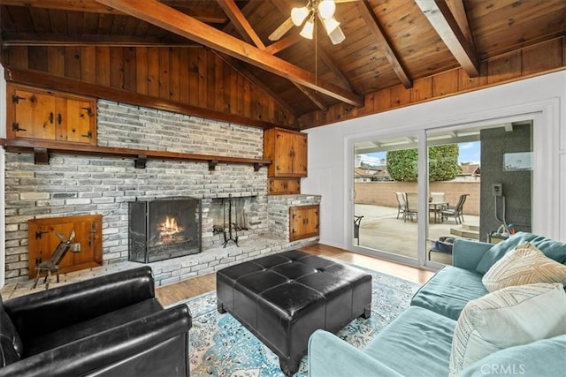 living area with wood finished floors, wooden ceiling, a fireplace, ceiling fan, and vaulted ceiling with beams