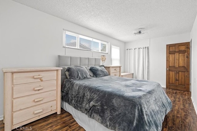 bedroom featuring dark wood finished floors and a textured ceiling