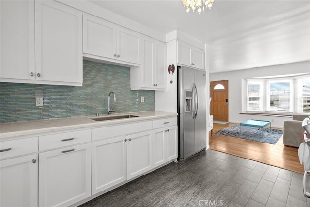 kitchen with dark wood-style flooring, a sink, light countertops, white cabinetry, and stainless steel fridge