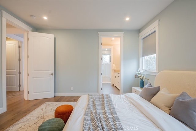 bedroom with ensuite bathroom, baseboards, wood finished floors, and recessed lighting