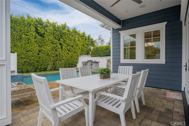 view of patio with outdoor dining space, a fenced in pool, a ceiling fan, and fence